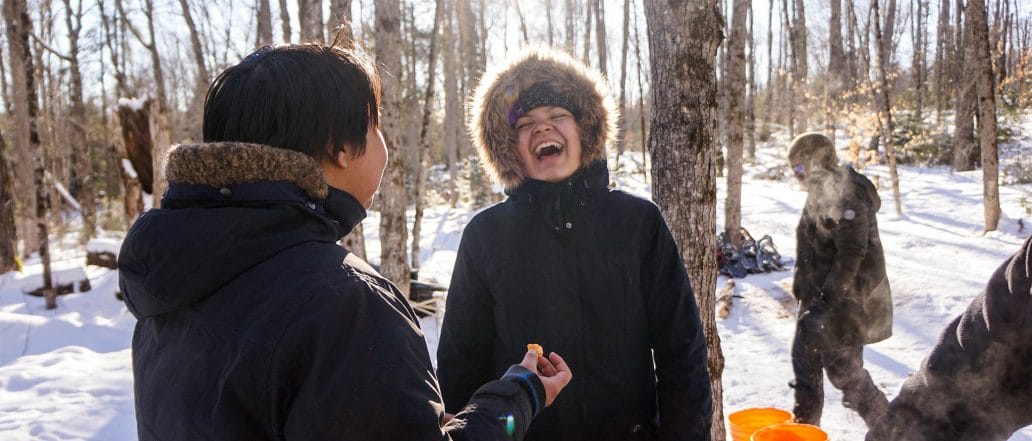 Image of two teens laughing in the forest