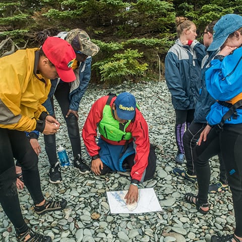 Six people gathered around a map