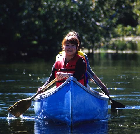 participants paddling a blue canoe smiling