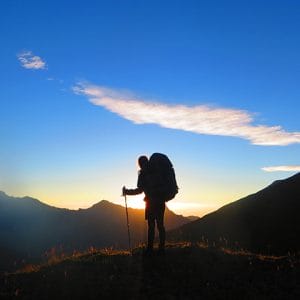 Silhouetted hiker watching sunset