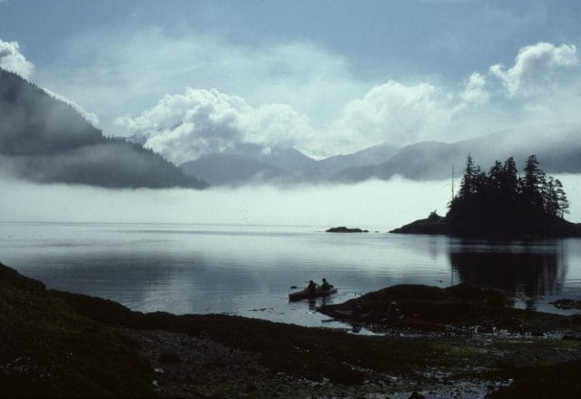 foggy mountains over lake with kayakers
