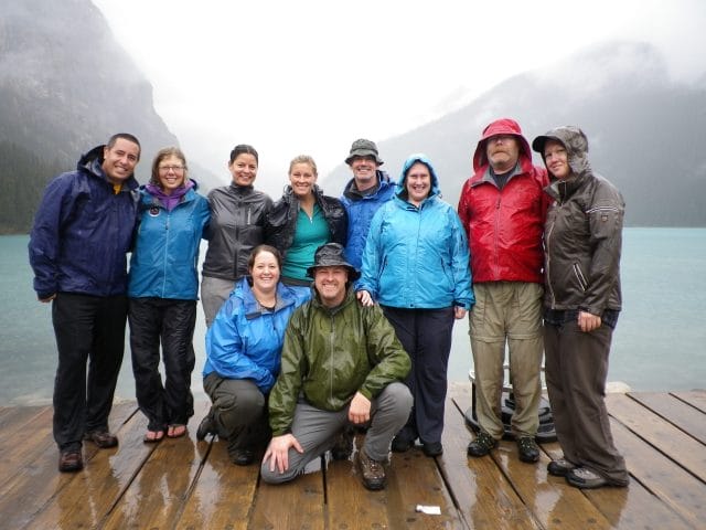 Group posing for photo on a doc in rain jackets