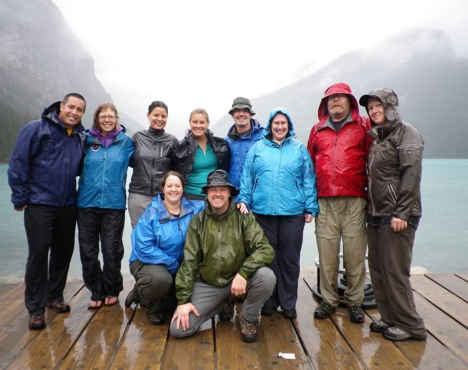 Group posing for photo on a doc in rain jackets