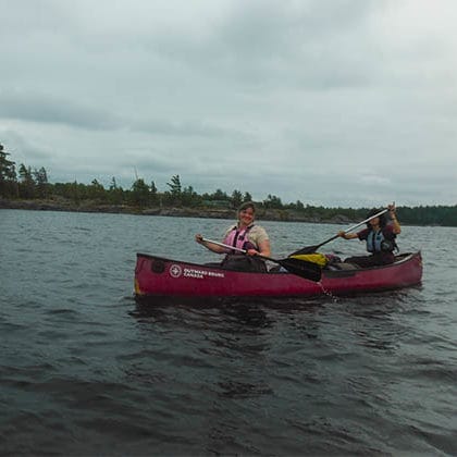Image of two people canoeing happily in flatwater