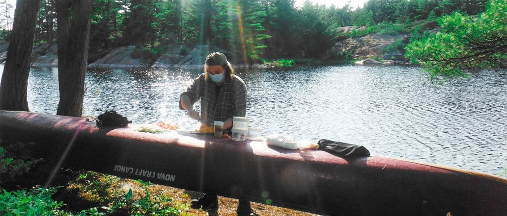 Image of a person preparing food on upside down canoe