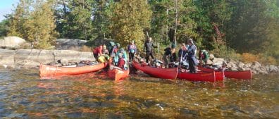 Image of a group placing their stuff on canoe before starting their expedition