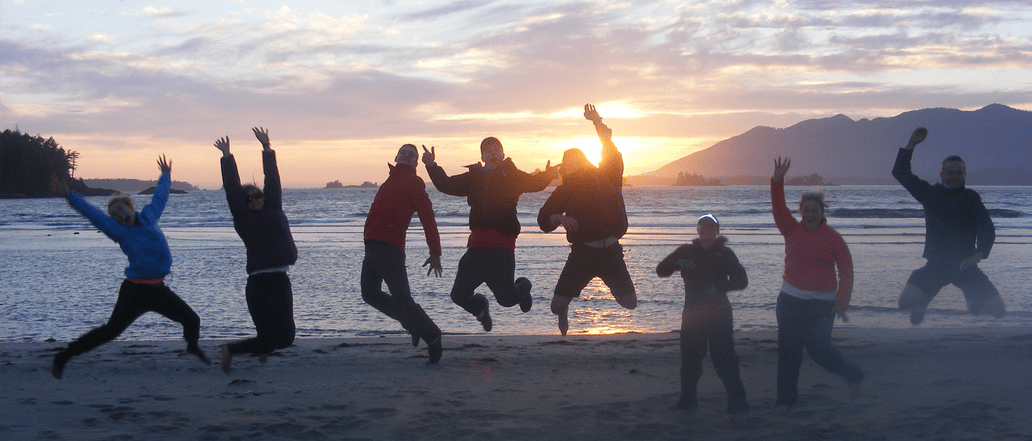 Image of a group, jumping at seashore
