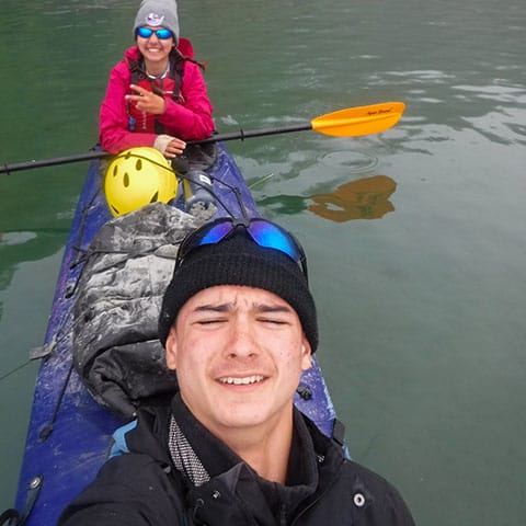 Image of 2 people in a tandem kayak taking a selfie