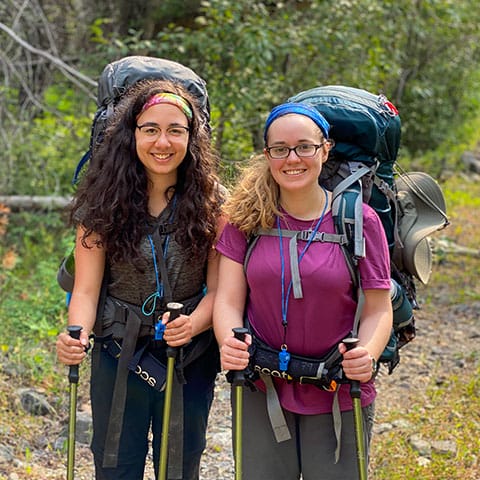 Image of two backpackers smiling while standing side by side