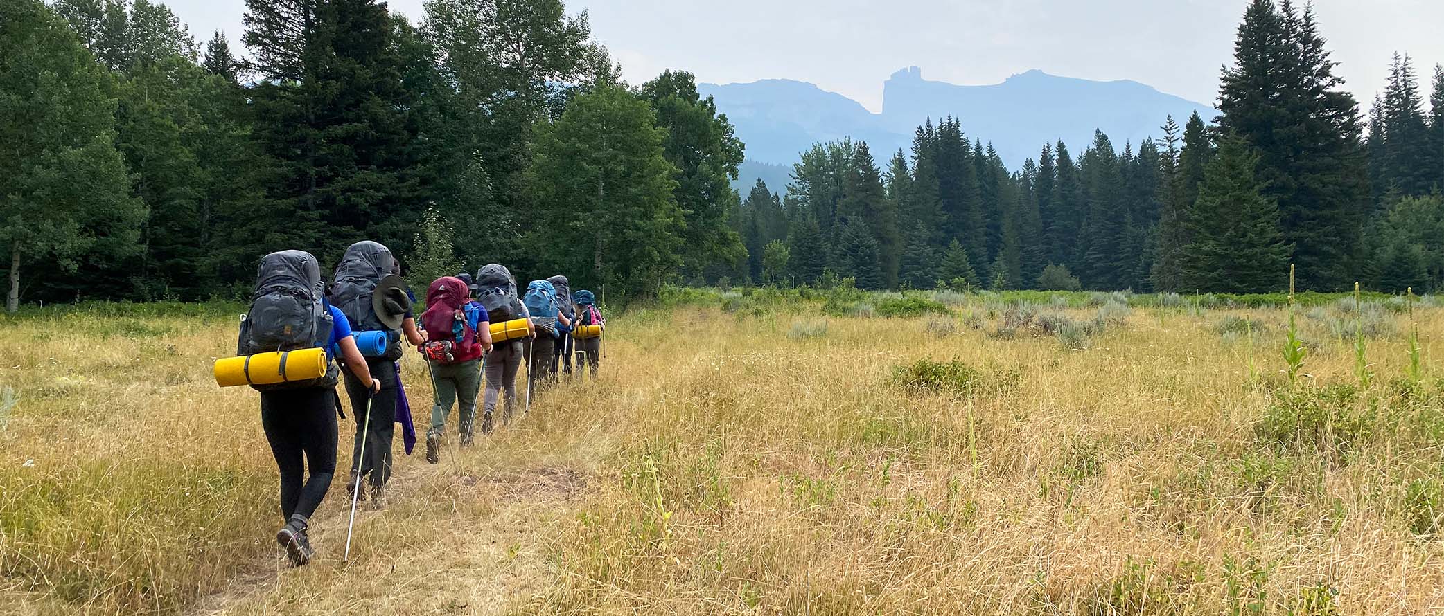 Image of a line of backpackers on a traill