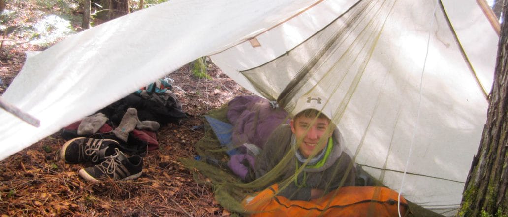 Image of a teen lying in the tent happily