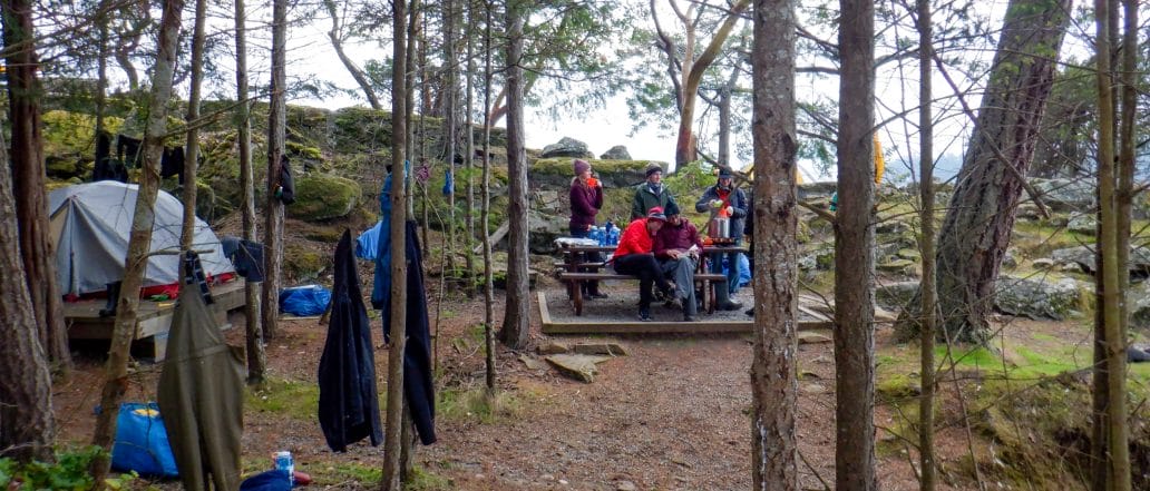 Image of a campsite set with a group around a picnic table