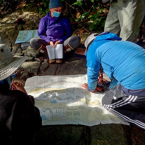Image of 3 people pouring over a map