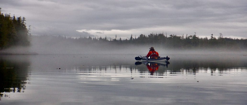 Image of a kayaker on foggy still water