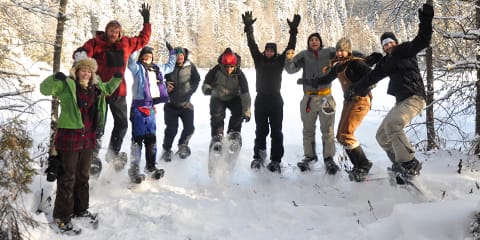 A group of snowshoers jumping in the air