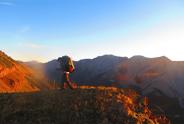 Image of a backpacker, backpacking on a sunny day on the mountain