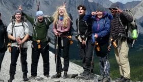 A group of teenage backpackers in front of a mountain