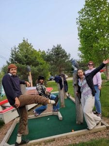 group of instructors smiling at the camera while mini golfing