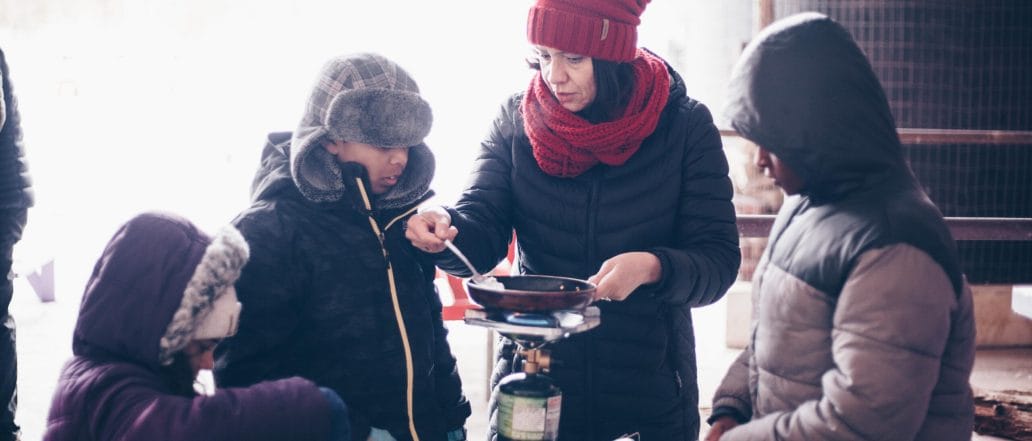 group of teens cooking in winter clothes