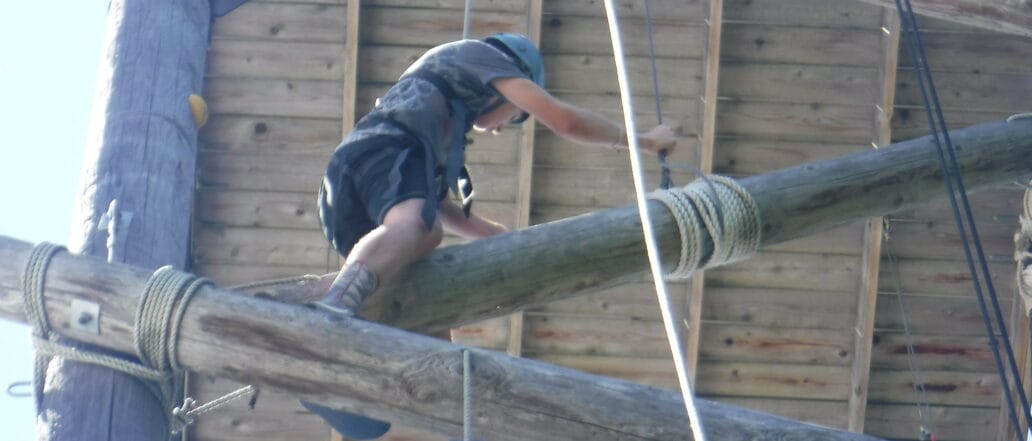 teen climbing high ropes