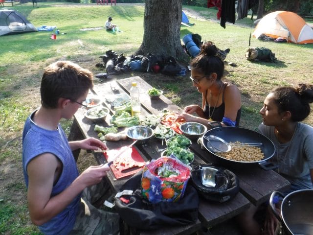 teens sitting at a picnic table eating