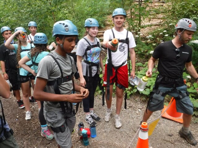 students gearing up for ropes climbing course