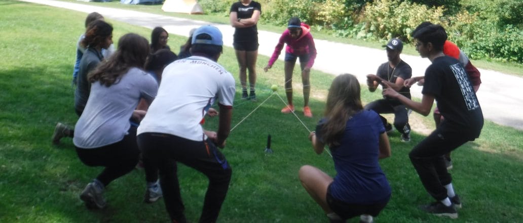 students engaging in a ropes course game