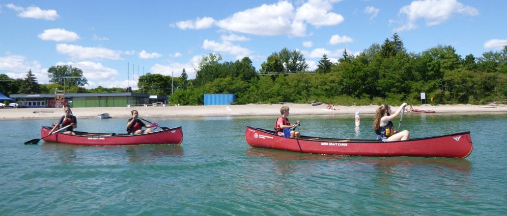 teens canoeing don valley with beach behind