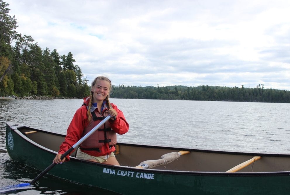 girl smiling in a canoe on a lake