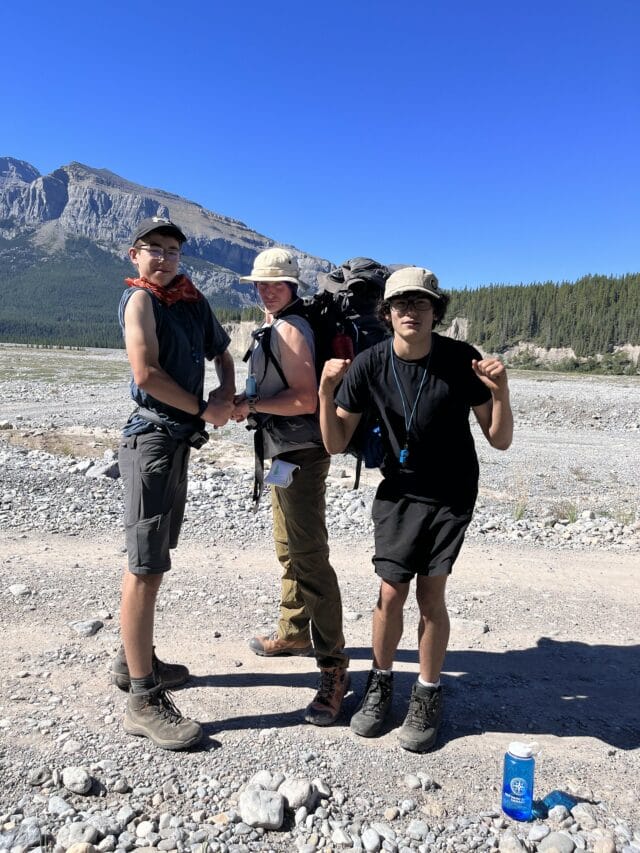 boys posing funny pose infront of mountain