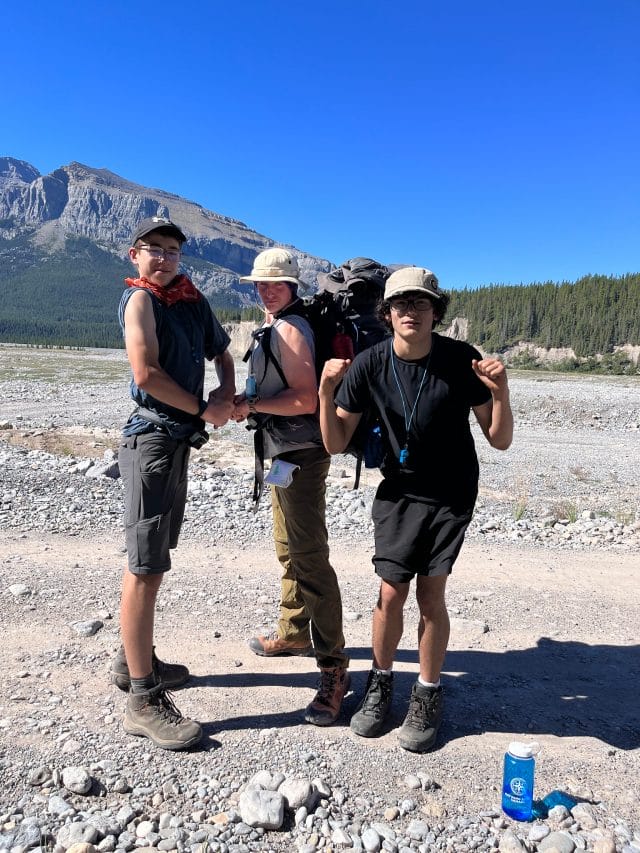 boys posing funny pose infront of mountain