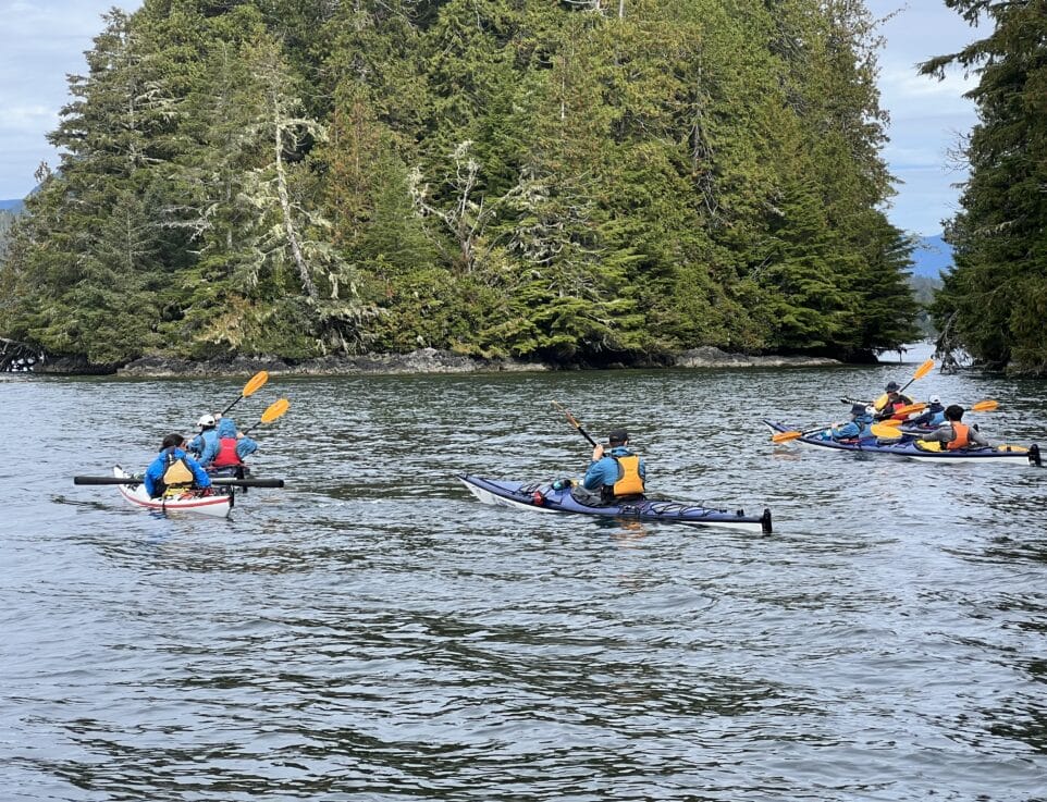 people in kayaks on a lake