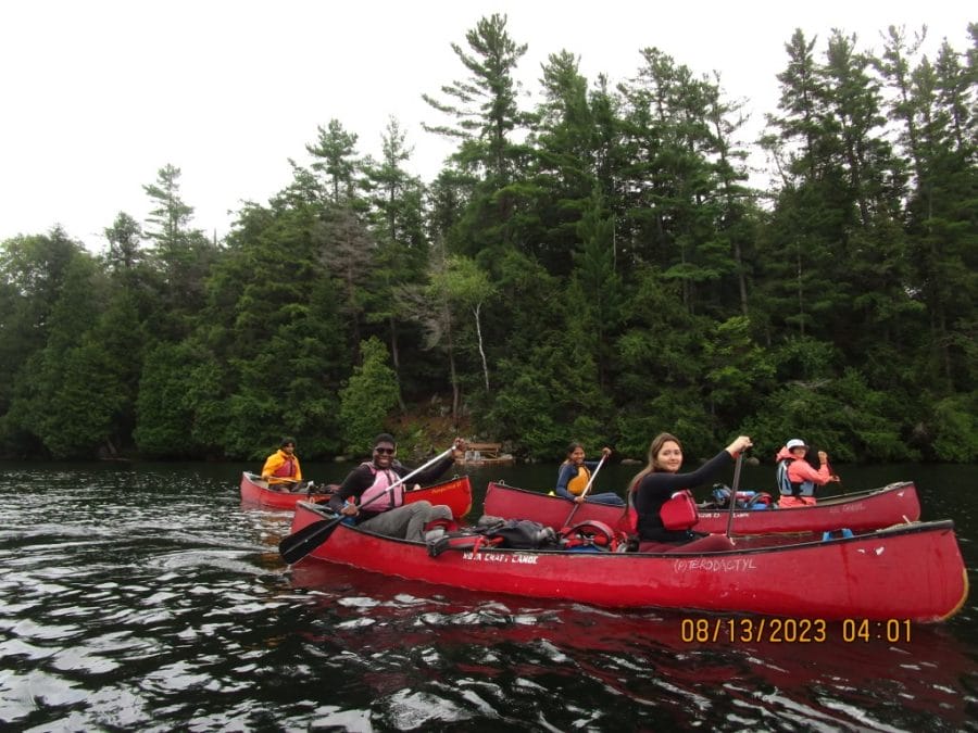 Group of Outward Bound Canada participants paddle on a lake in two canoes